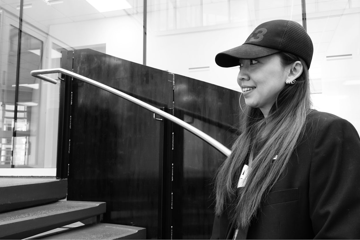 Rong Guan wearing a Y-3 hat, standing on a staircase.