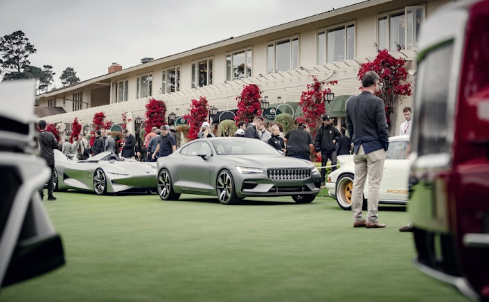 A metallic Polestar 1 parked between other sport cars, outside a fancy event entrance.