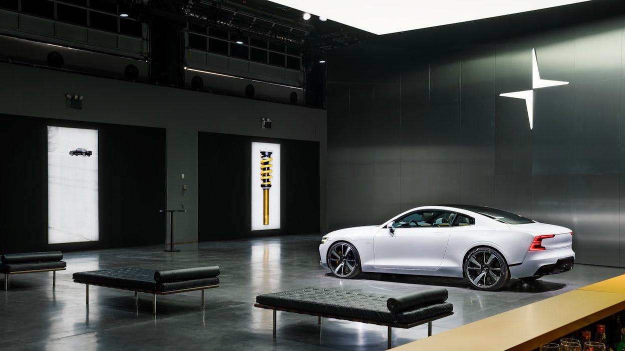 A white Polestar 1 displayed in a dark, minimalistic Polestar space.