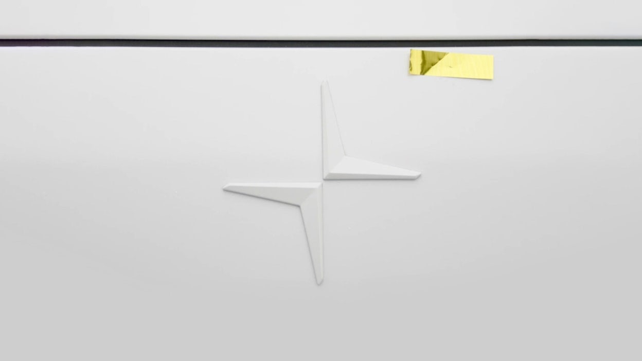 Close-up of a Polestar logo with a golden piece of tape placed on top.