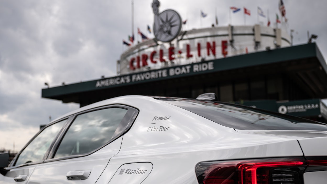 White Polestar 2 parked by entrance to Circle Line sightseeing cruises.