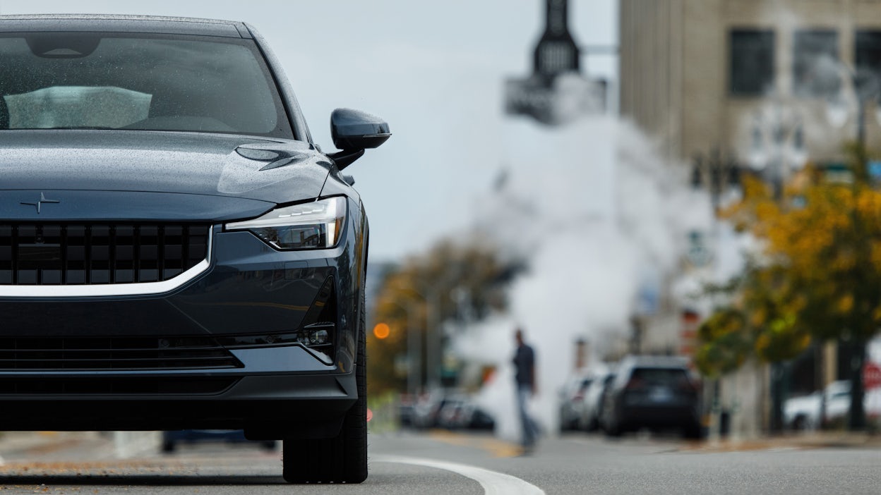 Front view of a blue Polestar 2 driving on the road.