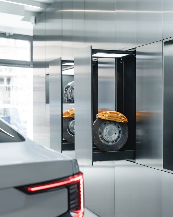 Taillight of Polestar 2 and open metal wall drawers showing Brembo break plates.