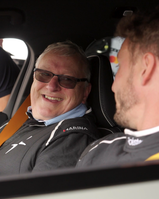 A driver and passenger sit inside a Polestar, wearing race suits.