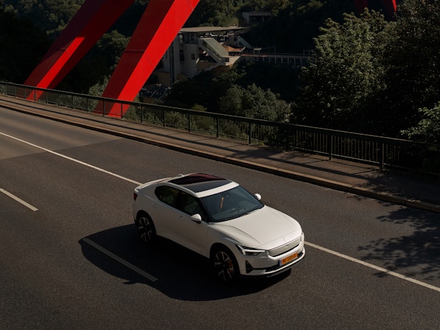 Polestar 2 blanche passant sous un fameux pont rouge au luxembourg