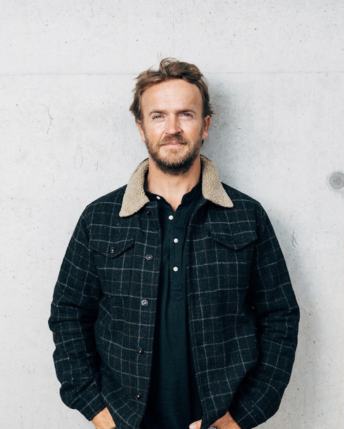 Portrait of Nick Hounsfield standing in front of white wall