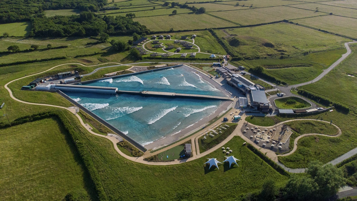 Aerial view of inland surfing lake surrounded by green fields