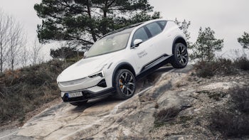 Witte elektrische Polestar 3 off road op een helling