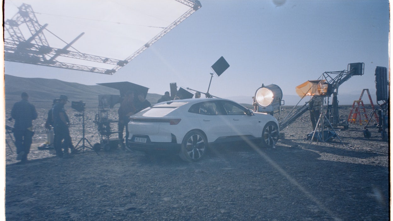 Polestar 4 in the desert surrounded by cameras and lights.