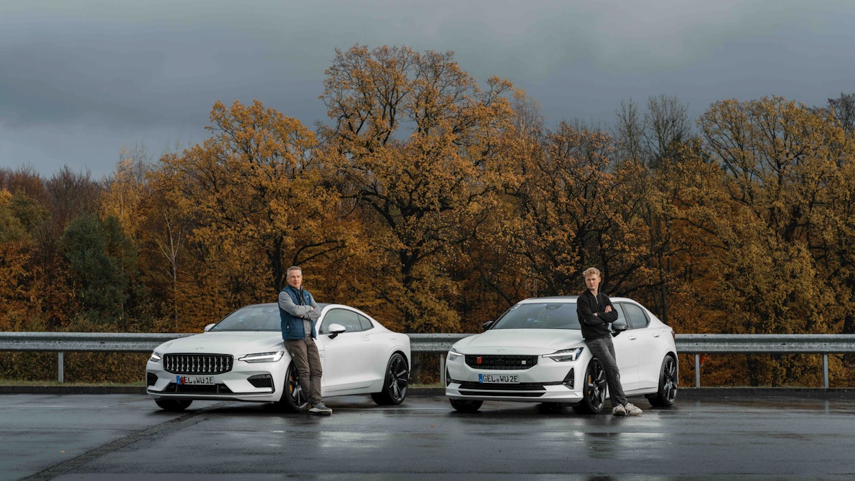 Two people standing in front of a Polestar 1 and 2