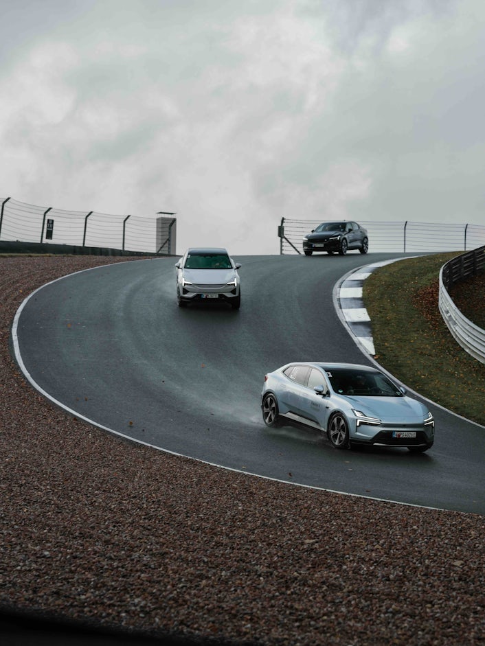 Three Polestars coming down a steep race track bend