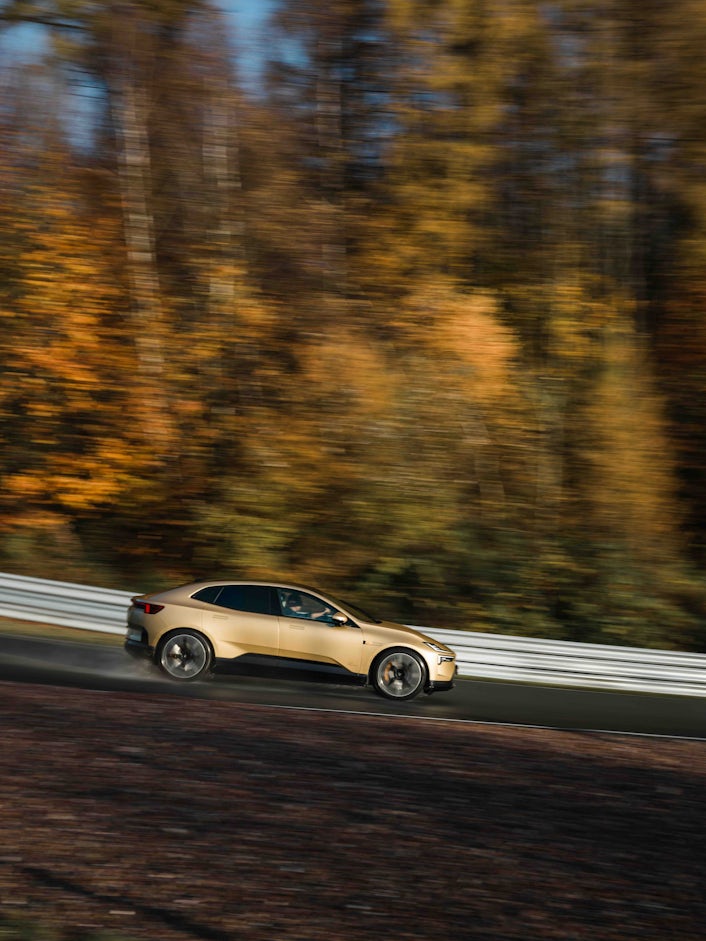 A gold Polestar 4 speeding on a race track