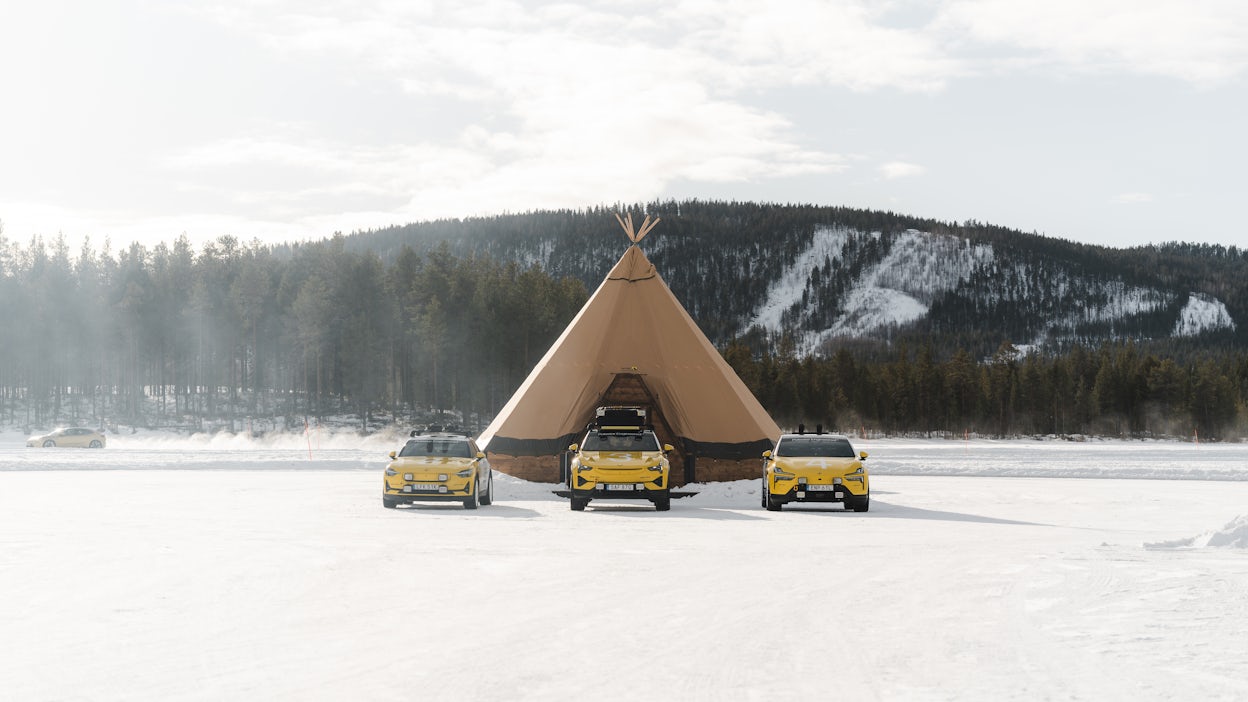 Large tipi with three cars parked in front